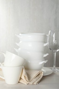 İçerideki açık ahşap masada farklı temiz bulaşık takımı.