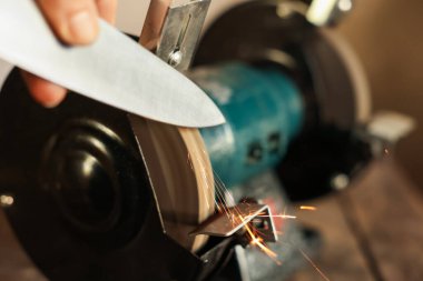 Bıçak keskinleştiren adam içeride, yakın plan.