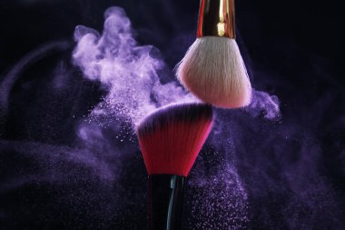 Siyah arka planda mor göz farlı makyaj fırçaları, yakın plan