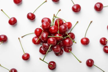 Beyaz arka planda taze kirazlar, düz uzanmış.
