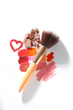 Beyaz arka planda farklı kozmetik ürünleri ve makyaj fırçası, düz konum