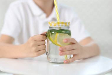 Masada limonata kavanozu olan küçük bir çocuk, seçici bir odak noktası. Tazeleyici içecek.