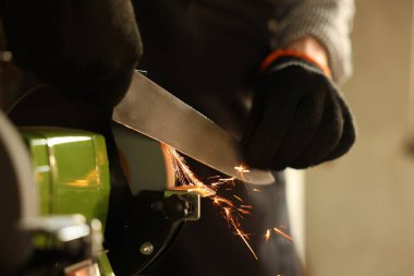 Bıçak keskinleştiren adam içeride, yakın plan.