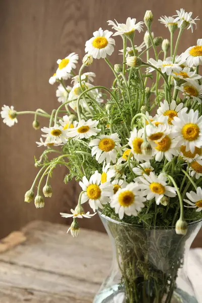 Güzel papatya çiçekleri cam vazoda, masada, yakın plan