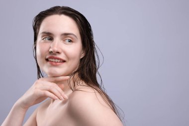 Gri arka planda doğal ten rengi olan gülümseyen kadın, yakın plan. Metin için boşluk