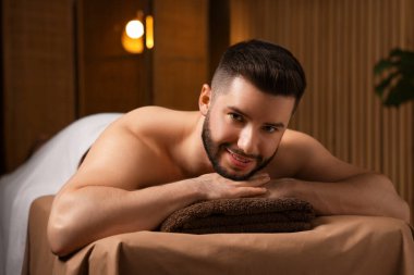 Güzellik salonunda masaj masasında yatan yakışıklı adam.