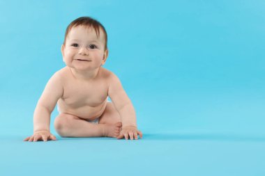 Açık mavi arka planda emekleyen şirin bir bebek. Metin için boşluk