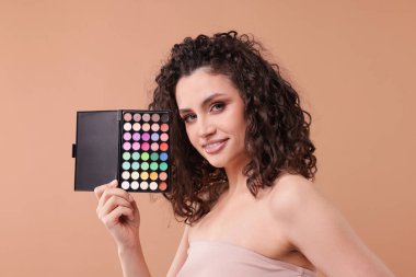 Bej arka planda göz falı olan gülümseyen kadın.