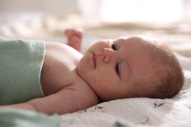 Sevimli yeni doğmuş bebek yatakta uzanıyor, yakın plan.