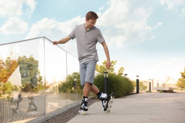 Mutlu adam şehir caddesinde paten kayıyor.