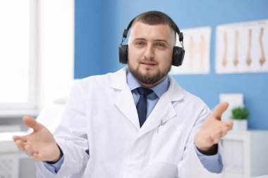 Kulaklıklı doktor içeride online danışmanlık yapıyor.