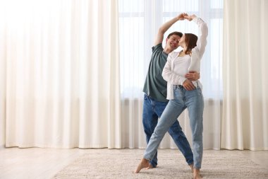 Mutlu genç çift evde dans ediyor. Metin için boşluk