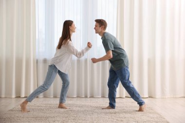 Mutlu genç çift evde dans ediyor.