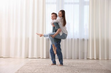 Mutlu genç çift evde dans ediyor.