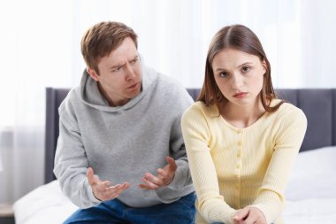 Kadın ve erkek evde yatakta kavga ediyorlar.