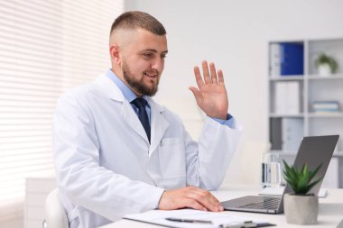 Klinikte bilgisayarla online danışmanlık yapan bir doktor