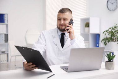 Akıllı telefonlu doktor klinikte online danışmanlık yapıyor.