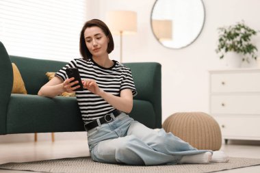 Evde modern akıllı telefon kullanan bir kadın. Metin için boşluk