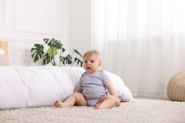 Evde yatağın yanında tatlı bir bebek var.