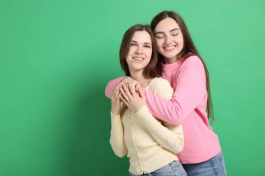 Mutlu arkadaşlar birbirine yeşil arka planda sarılıyor, mesaj için boşluk