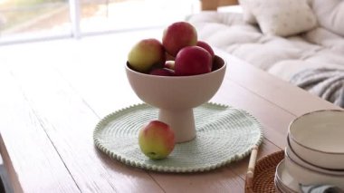 Elmalar ve temiz bulaşık takımı yemek odasındaki ahşap masada, kamera hareket ediyor.