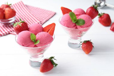 Şerbet, çilek ve nane şekerlerini beyaz ahşap masada, yakın plan.