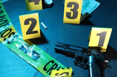 Adli tıp uzmanlığı. Deliller, işaretler ve mavi arka planda polis bandı olan suç mahalli, yakın plan. Renkli tonlama efekti