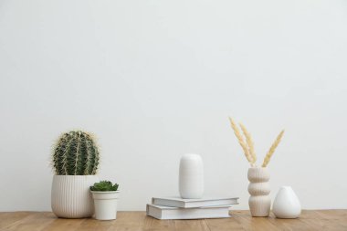 Beyaz duvarın yanındaki ahşap masada farklı bir dekor.