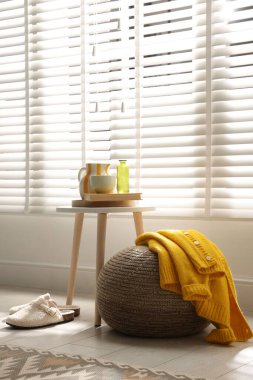 Evde süveter ile süslü püslü bir puf.