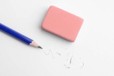 Beyaz arka planda kalem, silgi, karalama ve kırıntılar, düz uzanma