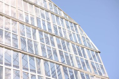 Mavi gökyüzüne karşı birçok penceresi olan modern bina, düşük açı görünümü