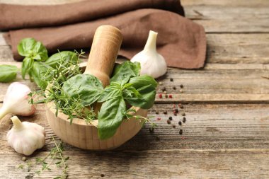 Kabuklu havan, ahşap masada farklı aromatik otlar ve baharatlar, metin için yer