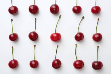 Beyaz arka planda taze kirazlar, düz uzanmış.