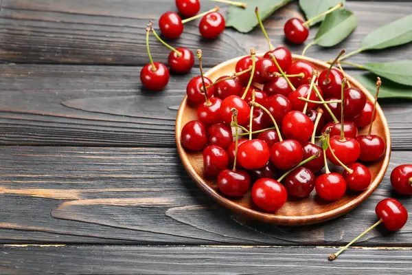 Siyah ahşap masada taze kirazlar, yakın plan. Metin için boşluk