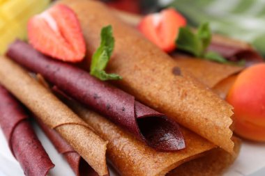 Lezzetli meyve dürümleri, nane ve çilek masada, yakın plan.