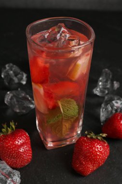 Çilek ve buzlu içecek karanlık masada, yakın plan.