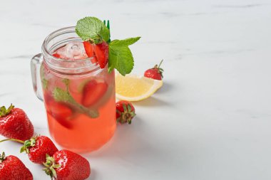 Çilekli içecek, beyaz masada buz ve nane şekeri, yakın plan. Metin için boşluk