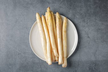 Gri desenli masa üzerinde çiğ beyaz kuşkonmaz mızrakları.