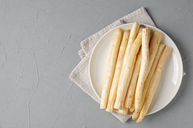 Gri desenli masa üzerinde çiğ beyaz kuşkonmaz mızrakları, üst manzara. Metin için boşluk