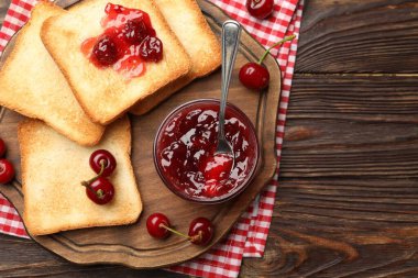 Lezzetli kiraz reçelli tostlar ve ahşap masada taze meyveler.