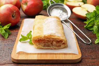 Lezzetli elmalı turta, pudra şekeri, nane ve ahşap masada meyveler, yakın plan.