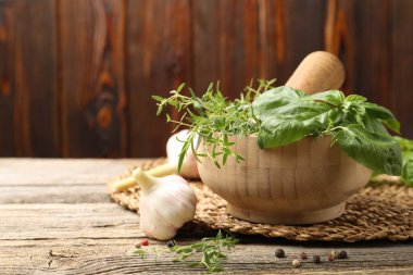 Kabuklu havan, ahşap masada farklı aromatik otlar ve baharatlar, yakın plan. Metin için boşluk