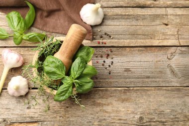 Kabuklu havan, farklı aromatik otlar ve ahşap masa üzerindeki baharatlar, düz yatak. Metin için boşluk