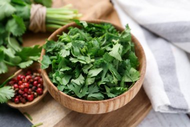 Taze yeşil kişniş ve biberler masada, yakın plan.