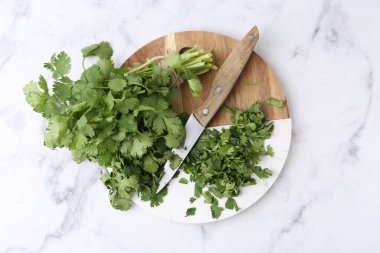 Taze yeşil kişniş ve bıçak beyaz mermer masa, üst manzara