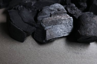 Gri masadaki siyah kömür parçaları, yakın plan.