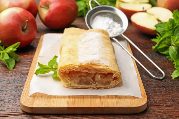 Lezzetli elmalı turta, pudra şekeri, nane ve ahşap masada meyveler, yakın plan.