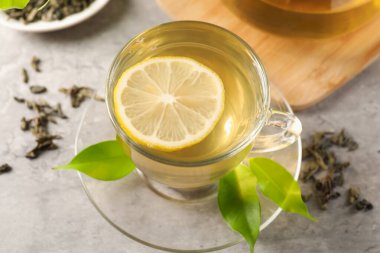 Yeşil çayı limonlu ve yapraklı serinletiyor.