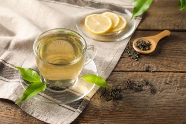 Limonlu yeşil çay ve ahşap masa yaprakları, yakın çekim