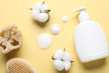 Düz bileşim, sarı zemin üzerinde sıvı sabun ve pamuk çiçekleri vardı.